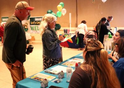People gather at an event with a "Let's Get Healthy" banner and balloons.