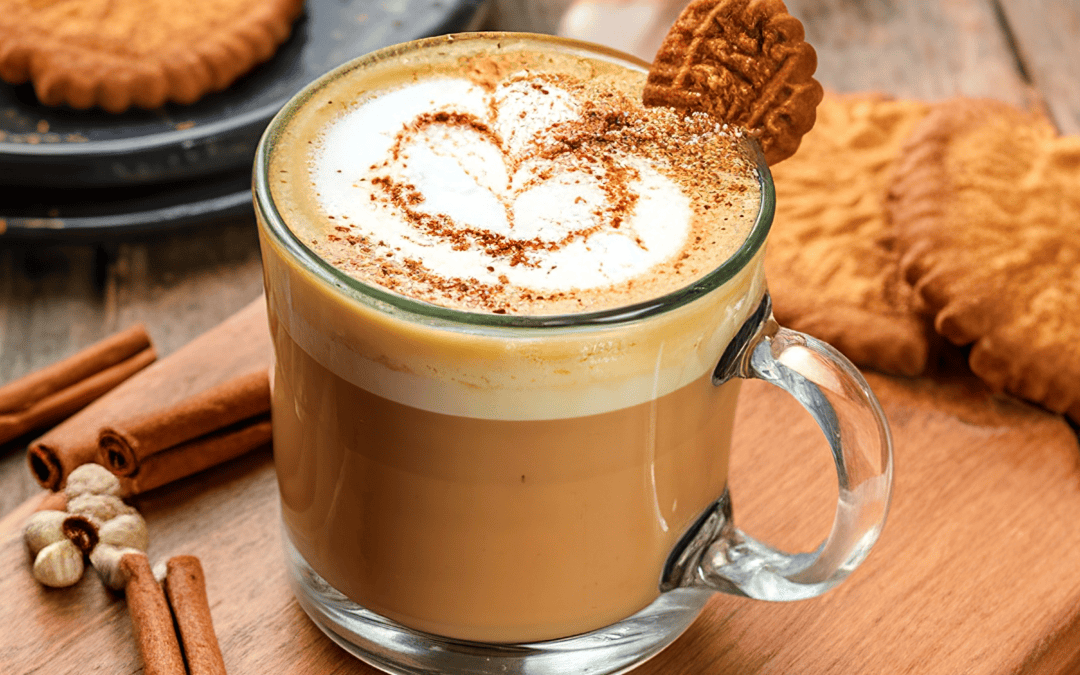 The classic Pumpkin spice latte in a glass mug with cinnamon, nutmeg and delicious cookies.